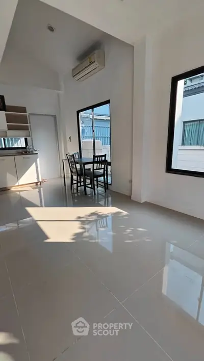 Bright and airy dining area with large windows and modern tile flooring, perfect for family gatherings.