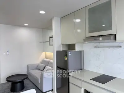 Modern apartment interior with sleek kitchen and cozy living area, featuring contemporary design and efficient layout.
