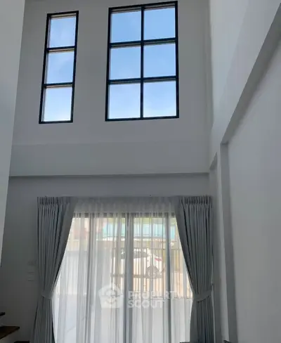 Spacious living room with high ceilings and large windows for natural light.