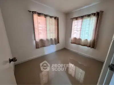 Bright empty room with tiled floor and two curtained windows