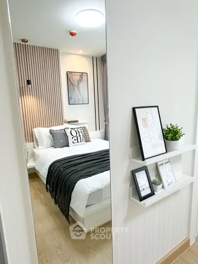 Modern bedroom with stylish decor and cozy ambiance, featuring elegant wall art and sleek shelving.
