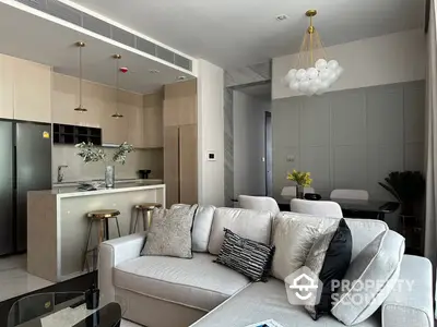 Chic modern living space with open kitchen layout, featuring elegant furnishings and contemporary lighting fixtures, perfect for urban living.