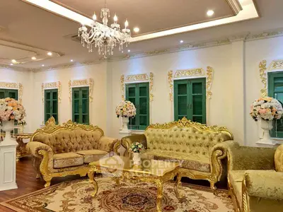 Luxurious living room with ornate gold furniture and elegant chandelier