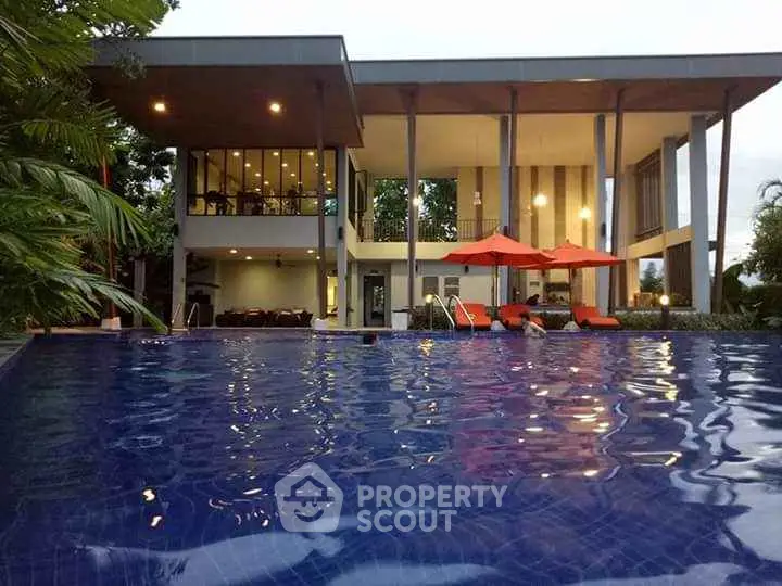 Luxurious modern home with stunning pool and outdoor seating area.
