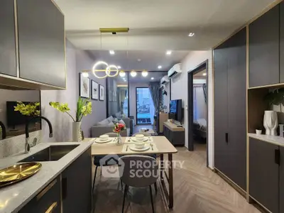 Modern open-plan kitchen and living room with elegant decor and stylish lighting.