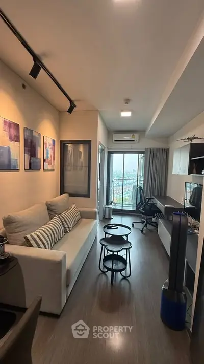 Modern living room with stylish decor and city view balcony in a cozy apartment.