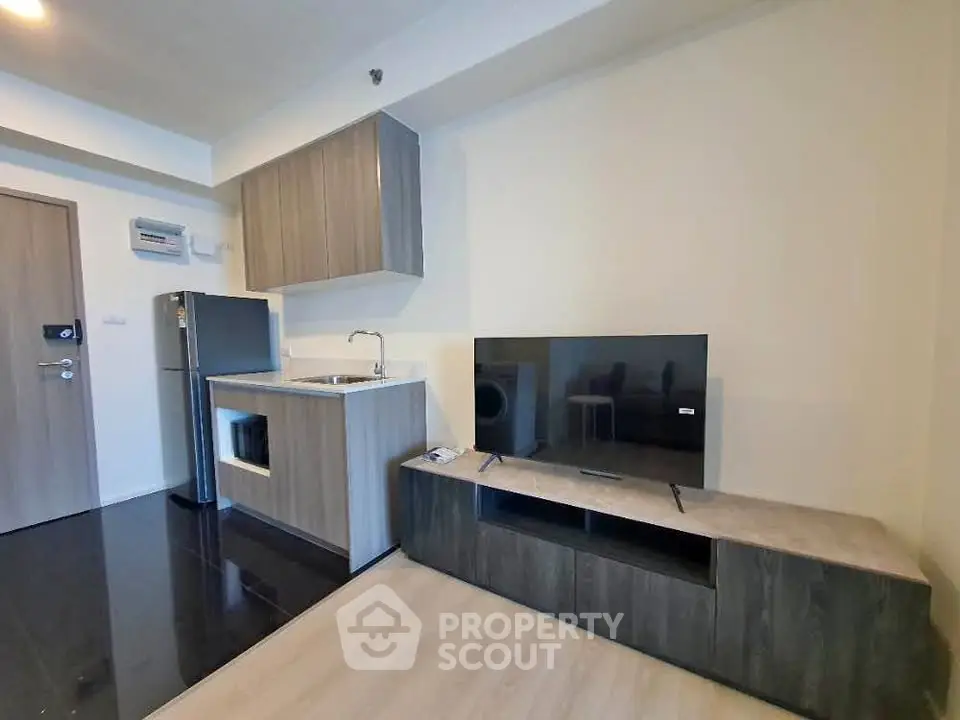 Modern apartment living room with sleek kitchen and flat-screen TV