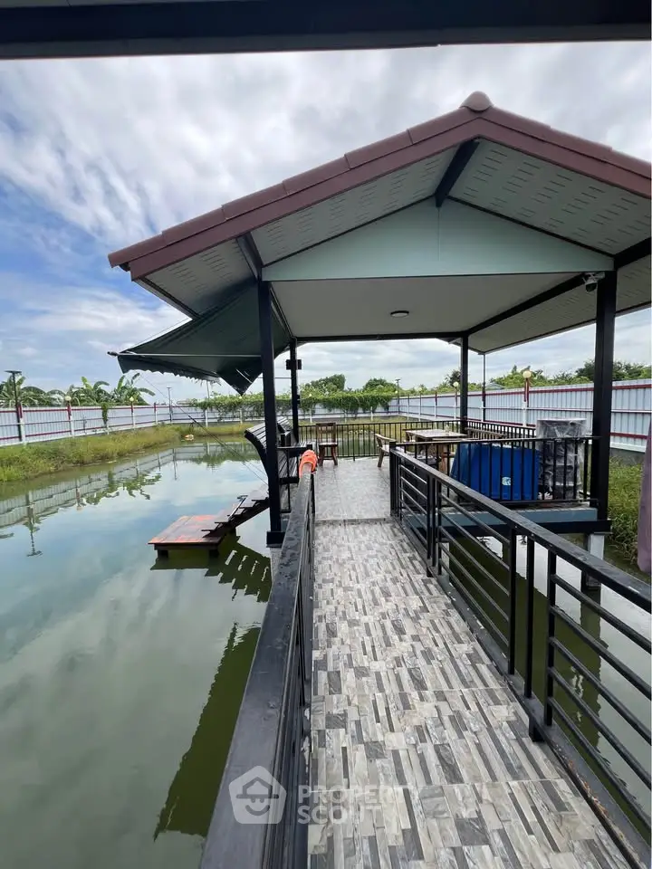 Stunning waterfront gazebo with tiled walkway and serene pond view, perfect for relaxation and outdoor gatherings.
