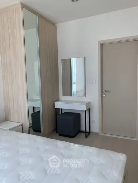 Modern bedroom with sleek wardrobe and stylish vanity in a minimalist design.