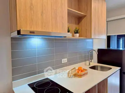 Modern kitchen with sleek design, featuring electric stove and stylish cabinetry.