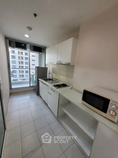 Modern kitchen with sleek appliances and city view from balcony