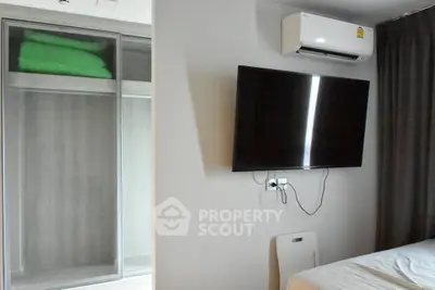 Modern bedroom with wall-mounted TV and air conditioner, featuring sleek wardrobe design.
