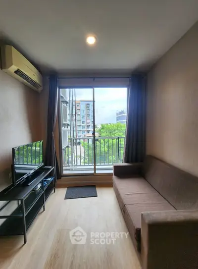 Modern living room with balcony view, featuring sleek furniture and natural light.
