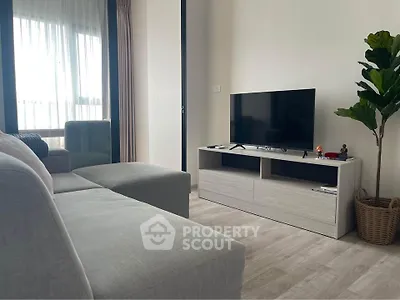 Modern living room with sleek TV stand, cozy sofa, and large window for natural light.