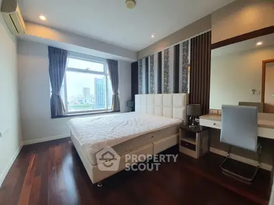 Luxurious bedroom with city view, elegant decor, and modern furnishings in a high-rise apartment.
