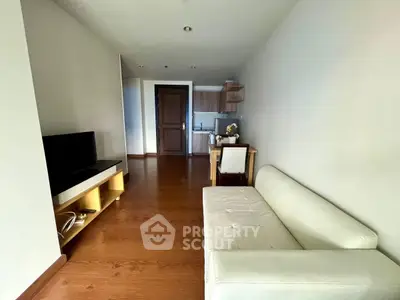 Modern living room with sleek furniture and open kitchen layout in a stylish apartment.