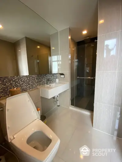 Modern bathroom with sleek fixtures and glass shower enclosure