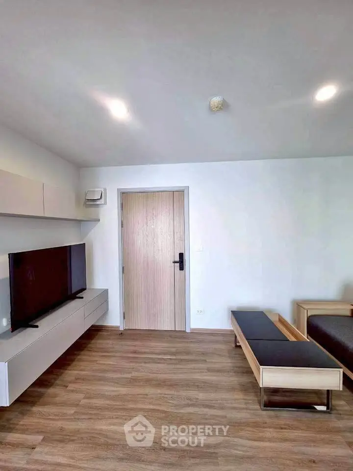 Modern living room with sleek furniture and mounted TV in a stylish apartment.