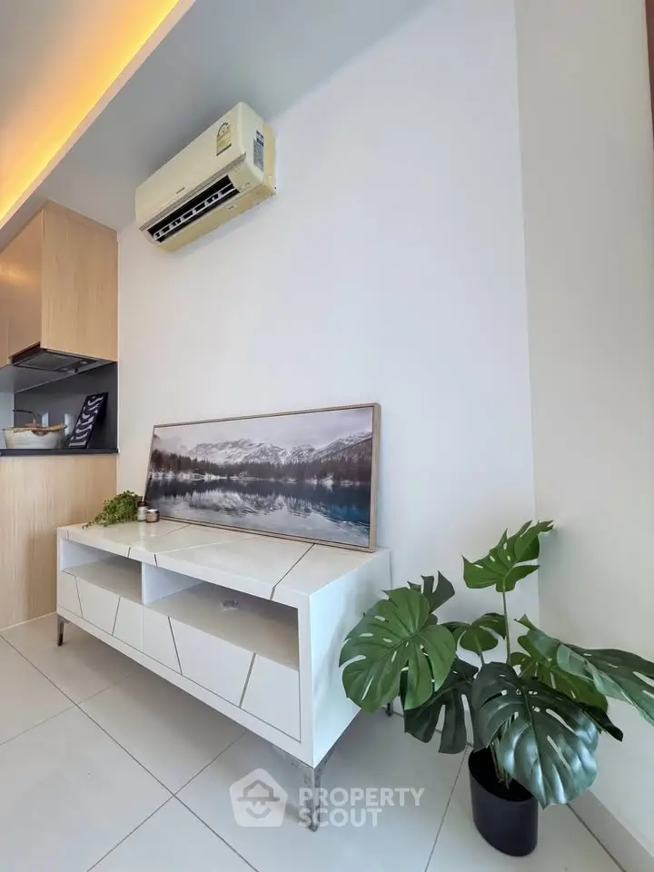 Modern living room with sleek furniture and air conditioning, featuring stylish decor and indoor plants.