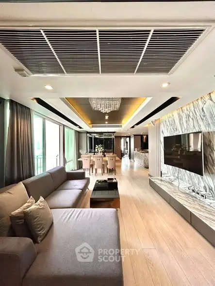 Luxurious open-plan living room with elegant decor and spacious dining area, featuring modern furnishings and ambient lighting.