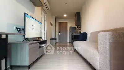 Modern living room with sleek furniture and wall-mounted TV in a stylish apartment.
