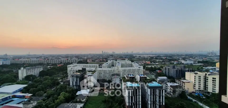 Stunning cityscape view from high-rise apartment at sunset, showcasing urban skyline and lush greenery.