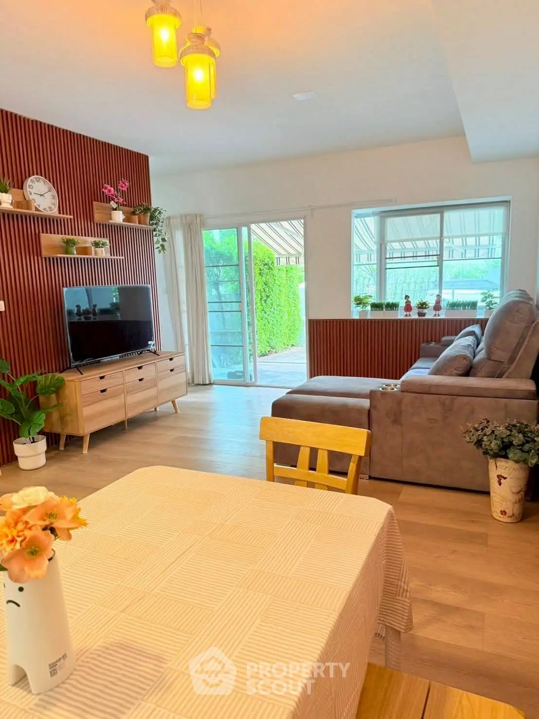 Charming living room with cozy decor and garden view, perfect for relaxation and entertainment.