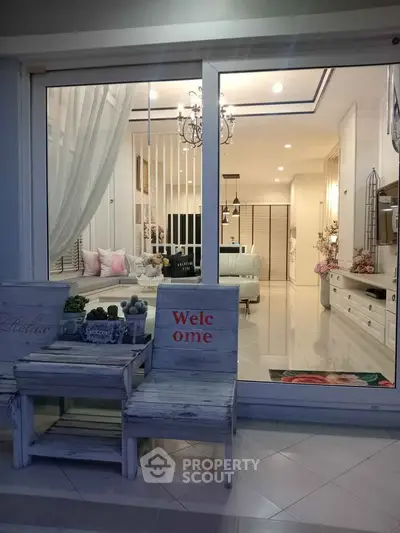 Elegant living room with chic decor and cozy seating area viewed from outside.