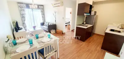 Charming open-plan living and dining area with modern kitchen in cozy apartment.