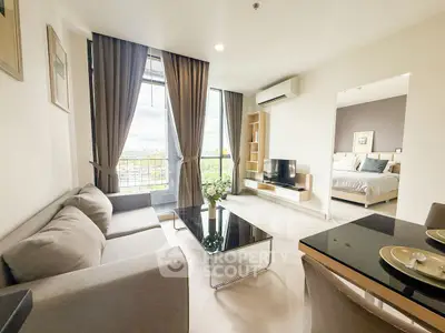Modern living room with elegant decor and natural light, adjacent to a cozy bedroom.