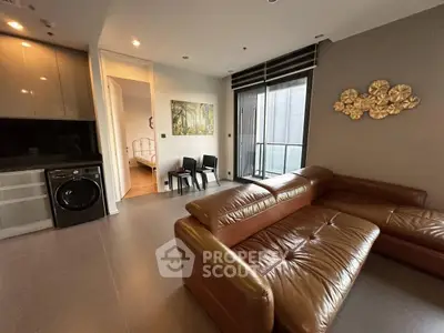 Modern living room with leather sofa and washing machine in open layout