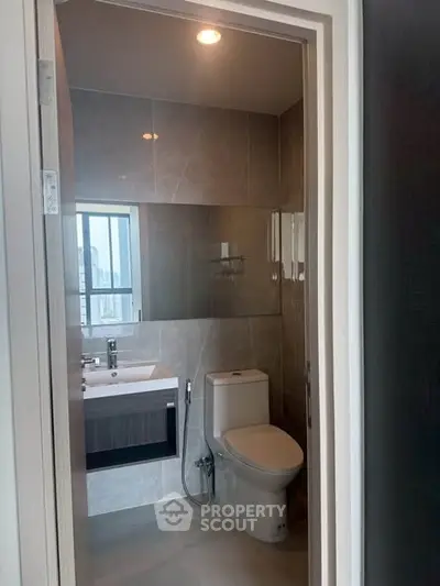 Modern bathroom with sleek fixtures and city view window, perfect for urban living.