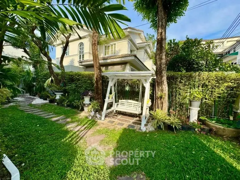 Charming garden with swing and lush greenery in front of elegant house