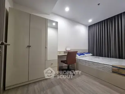 Modern bedroom with sleek wardrobe and cozy single bed, perfect for urban living.
