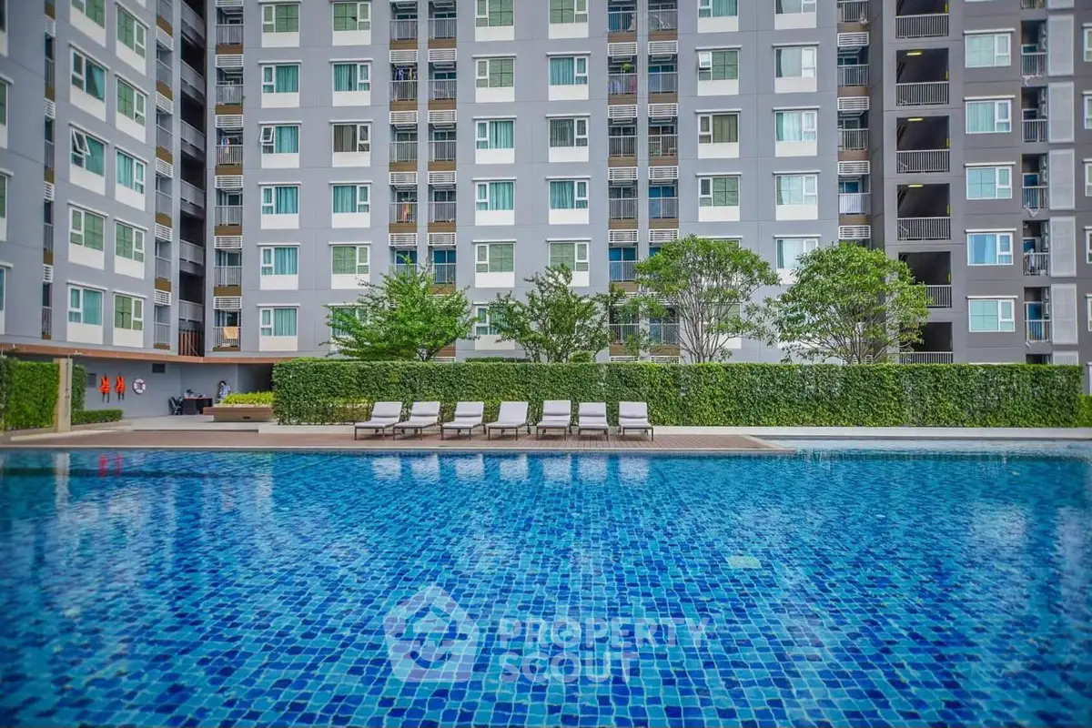 Luxurious apartment complex with inviting swimming pool and modern exterior design.