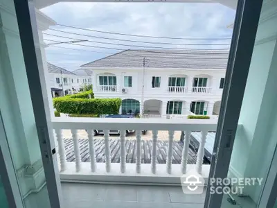 Charming townhouse view from balcony with classic railing and serene neighborhood.