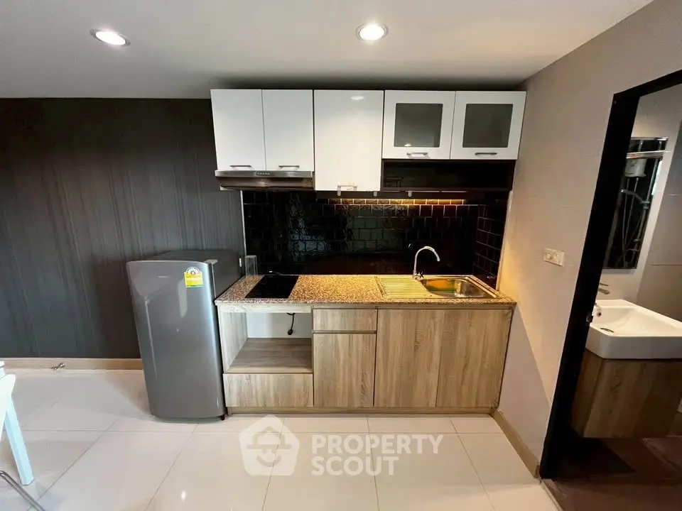 Modern kitchen with sleek cabinets and granite countertop in stylish apartment.