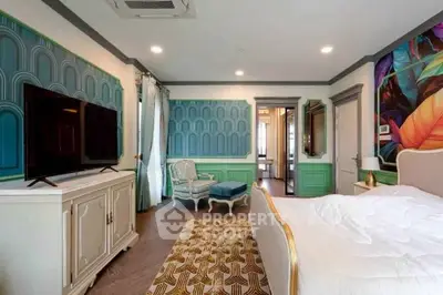 Luxurious bedroom with elegant decor and large TV, featuring stylish furniture and vibrant wall art.