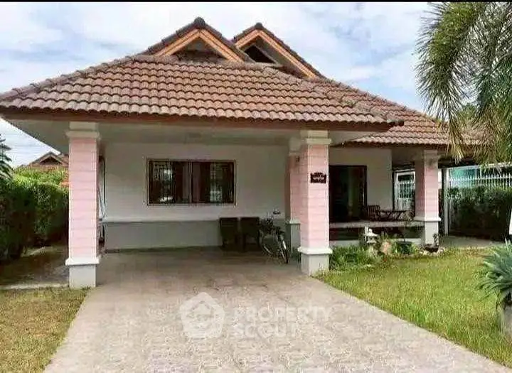 Charming single-story house with tiled roof and spacious driveway in a serene neighborhood.