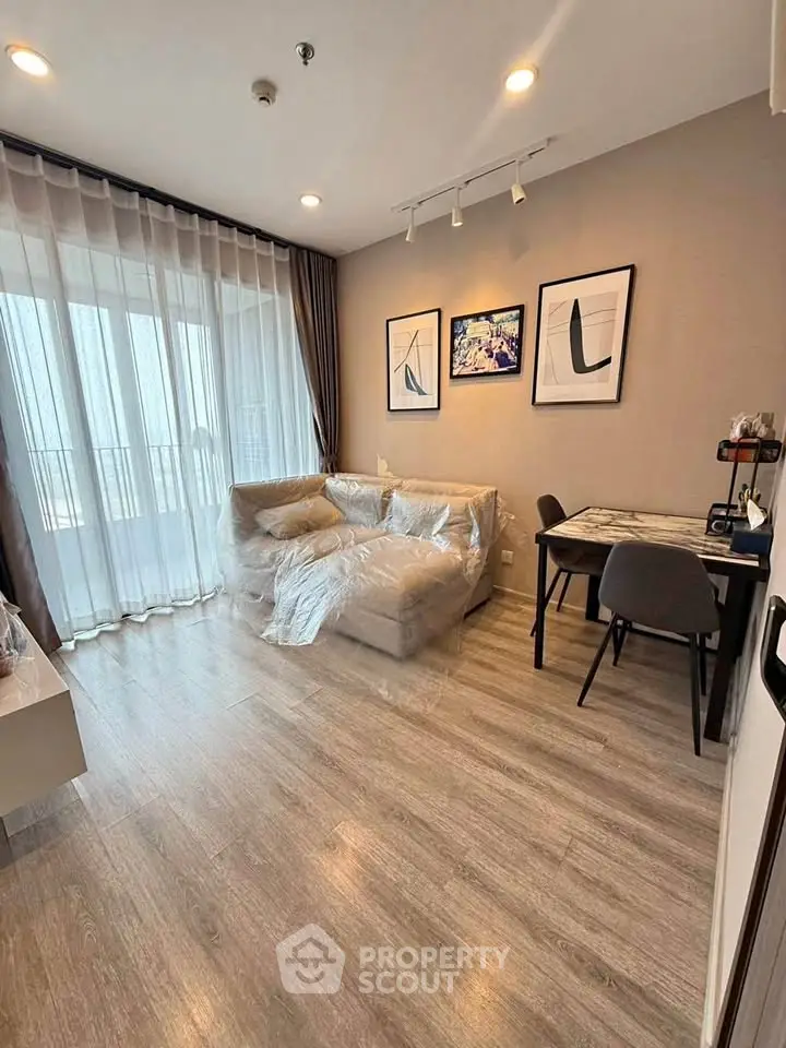 Modern living room with cozy sofa, dining area, and large windows in a stylish apartment.