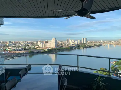 Stunning balcony view overlooking a serene river and city skyline, perfect for relaxation.