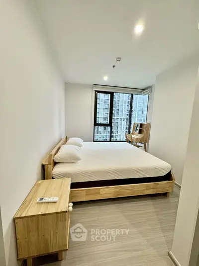 Modern bedroom with large window and wooden furniture in high-rise apartment