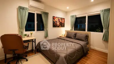 Cozy bedroom with modern decor, featuring a comfortable bed, desk, and stylish artwork, perfect for relaxation.