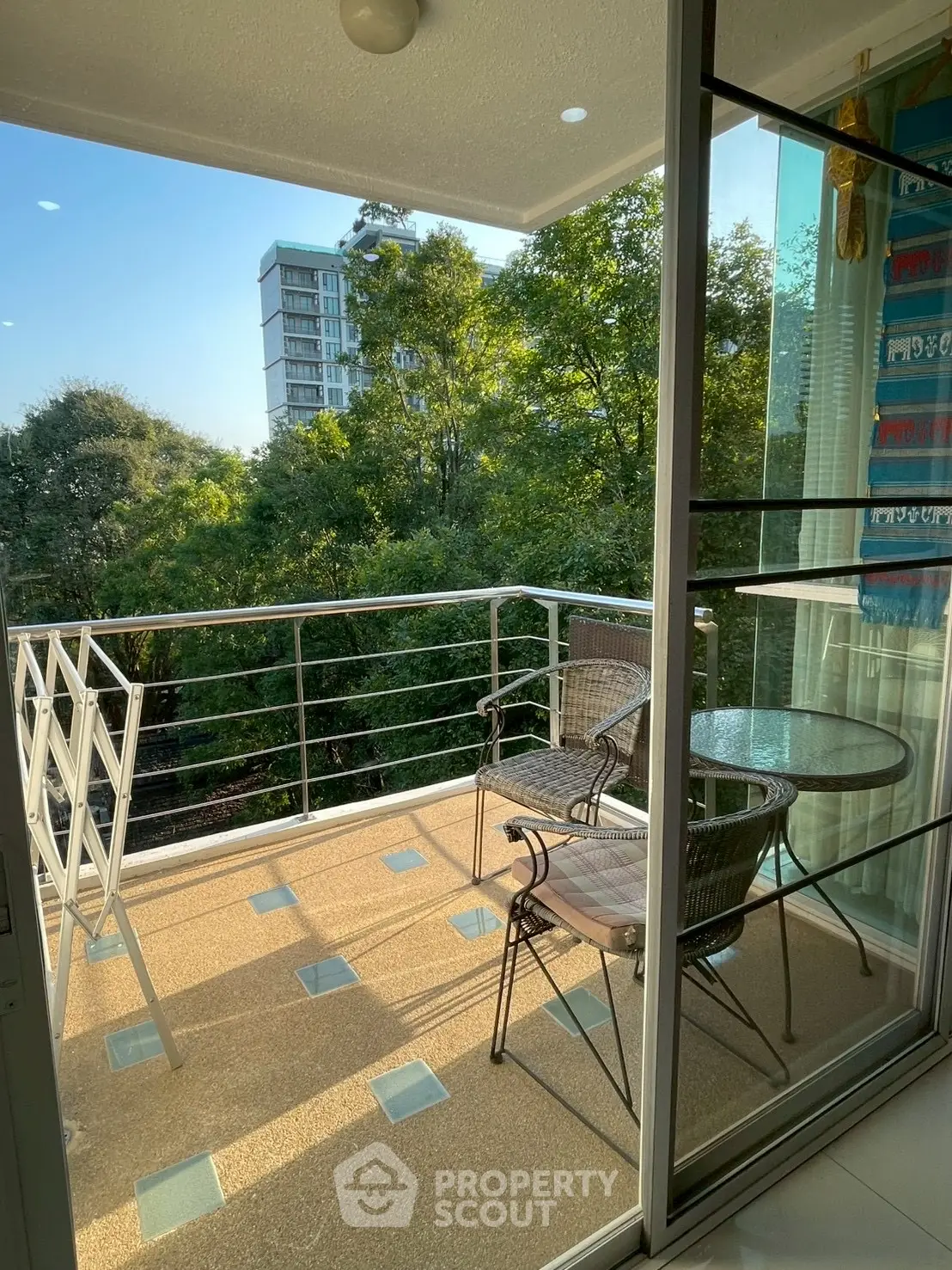 Charming balcony with seating and lush green view, perfect for relaxation.
