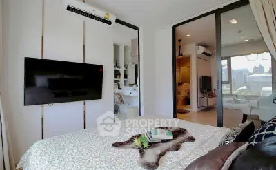 Modern bedroom with wall-mounted TV and city view, featuring stylish decor and air conditioning.