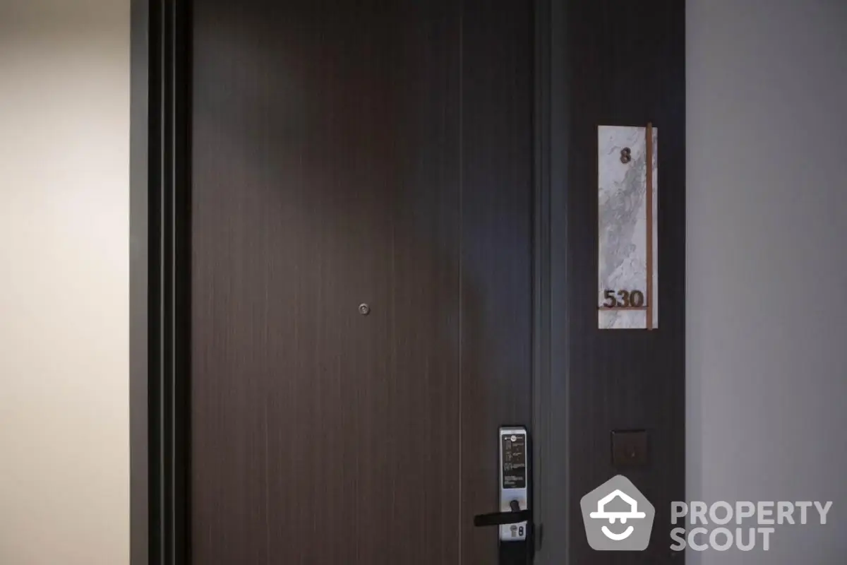 Modern apartment entrance with electronic lock and room number