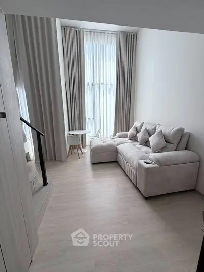 Modern living room with elegant sofa and floor-to-ceiling windows in a stylish apartment.