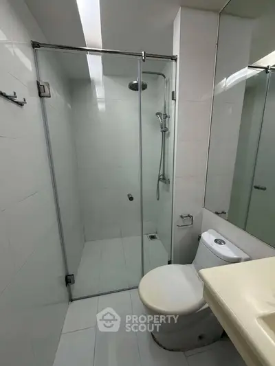 Modern bathroom with glass shower enclosure and sleek fixtures