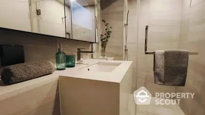 Modern bathroom with sleek design featuring glass shower and elegant fixtures.