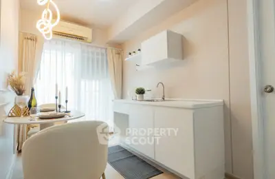 Modern minimalist kitchen with sleek white cabinets and elegant dining setup.